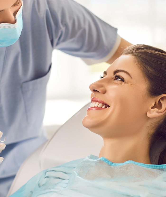 Dental team member smiling at a patient in the treatment chair